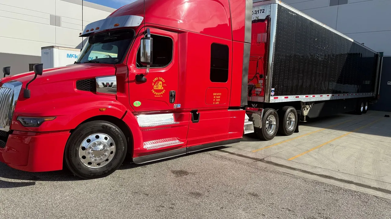 Fire Chief Transport's red truck and 53-ft dry van at a cargo dock