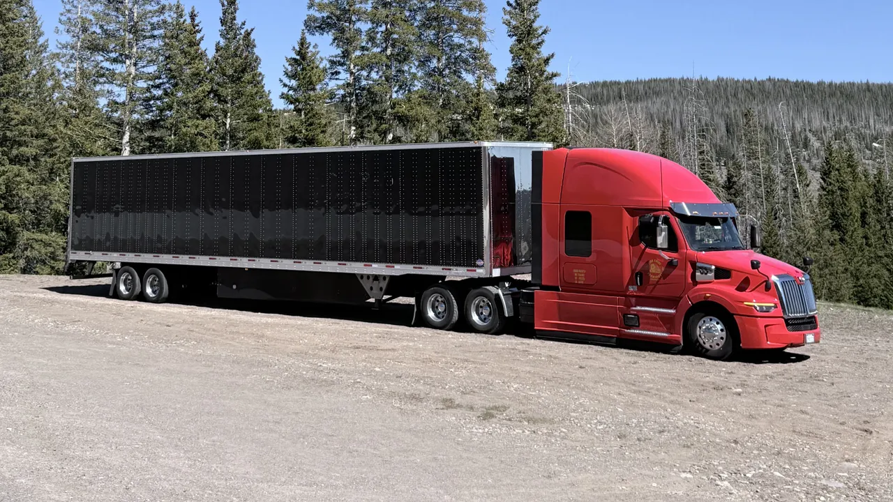 Fire Chief Transport's red truck and trailer at a mountain pullout