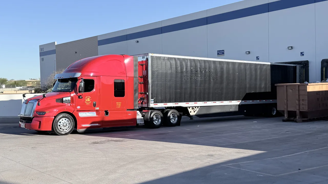 Fire Chief Transport's red Western Star and trailer at a sunny loading dock