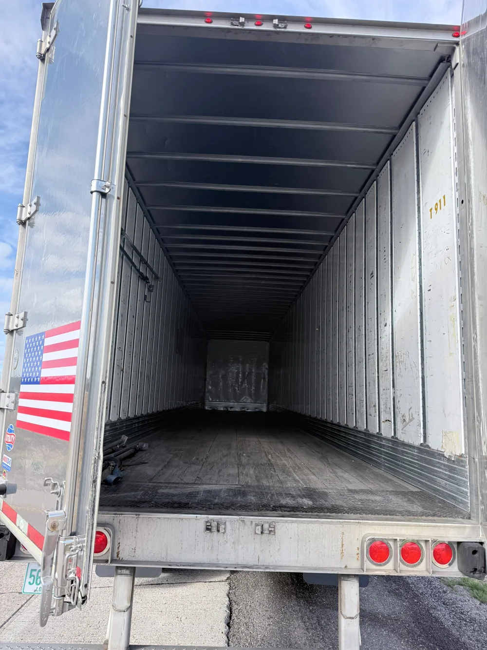 Clean empty dry-van interior with an American flag