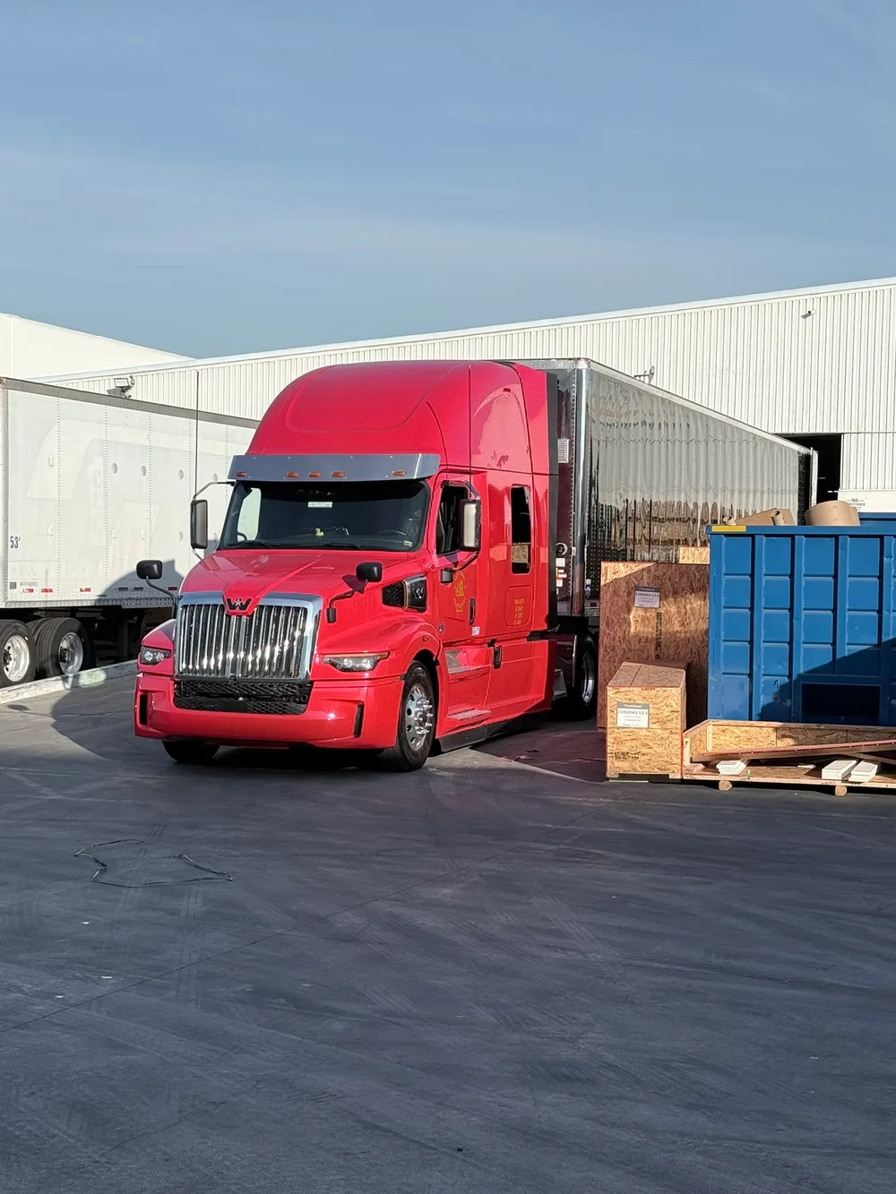 Red truck backed into a warehouse loading dock